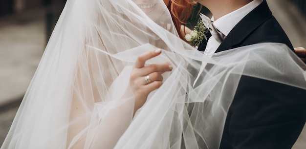 Groom carries charming bride on his arms Free Photo