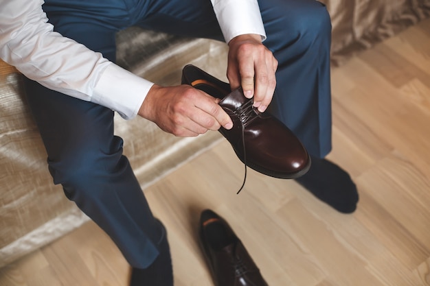 Premium Photo | Groom putting his wedding shoes. hands of wedding groom ...