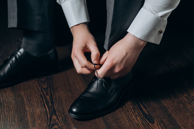 Free Photo | Groom ties laces on his shoes