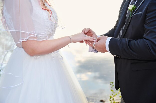 Premium Photo Groom Wears A Wedding Ring On The Brides Hand