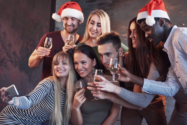 Premium Photo Group Beautiful Young People Doing Selfie In The New Year Party Best Friends Girls And Boys Together Having Fun Posing Emotional Lifestyle People Hats Santas And Champagne Glasses In