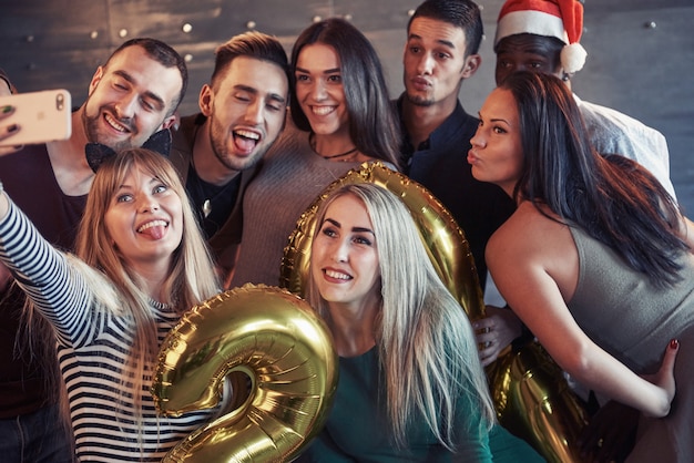 Premium Photo Group Beautiful Young People Doing Selfie In The New Year Party Best Friends Girls And Boys Together Having Fun Posing Lifestyle People Concept Hats Santas And Champagne Glasses In