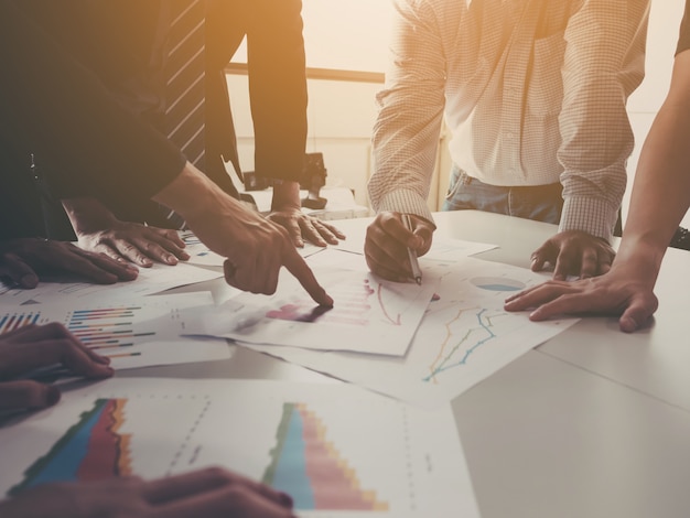 Group of businessman meeting analyze the company performance and growth corporate with information data paper. Premium Photo