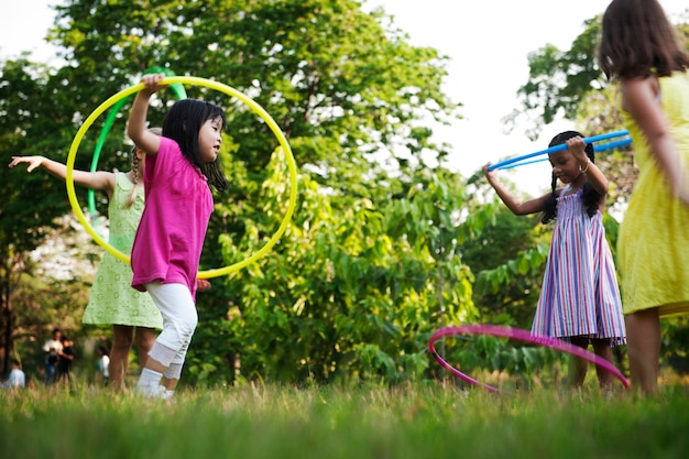 Premium Photo | Group of diverse kids playing hula hoop in the park ...