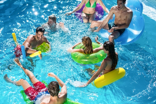 Premium Photo | Group of friends having fun in swimming pool