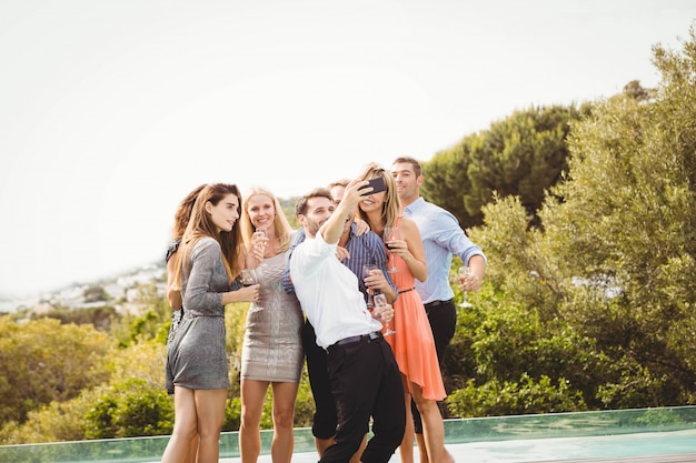 Group of friends taking a selfie near the swimming pool in a resort Premium Photo