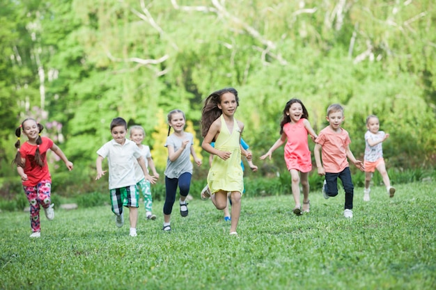 Premium Photo | A group of happy children of boys and girls run in the ...