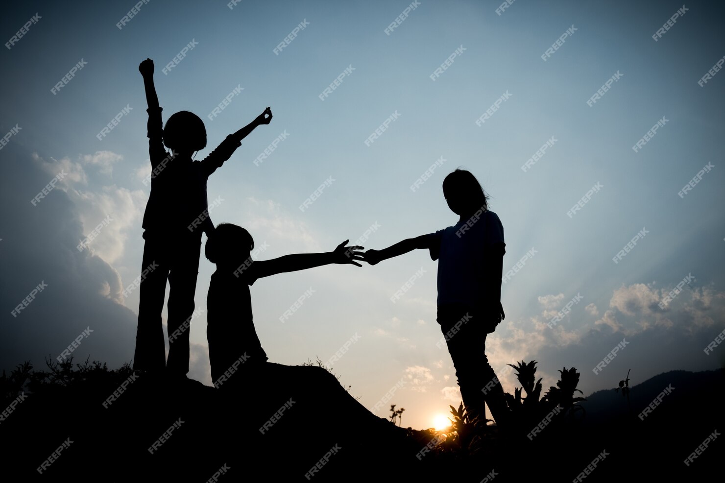 Premium Photo | Group of happy children playing on hill at sunset ...