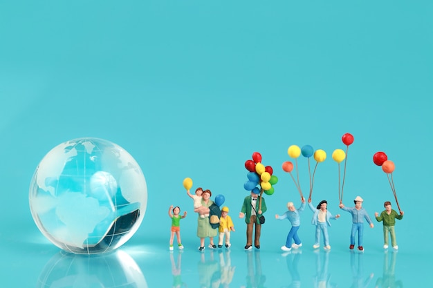A group of happy family are having fun and holding balloon with earth Premium Photo