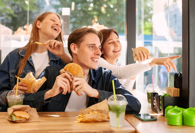 Free Photo | Group of happy friends eating burgers