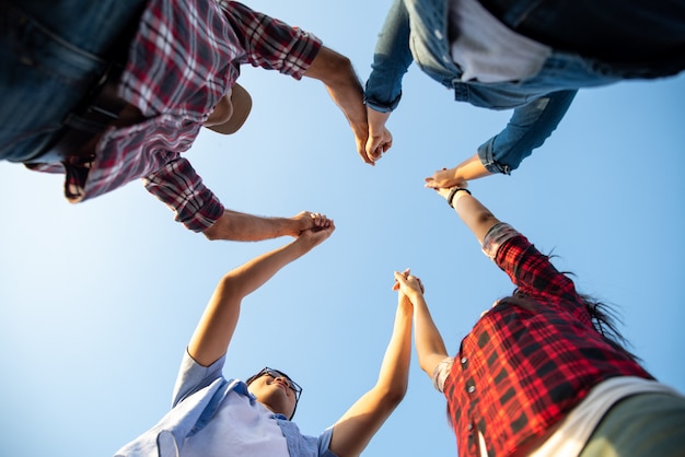 Premium Photo | Group of happy friends raised arms together, friendship ...