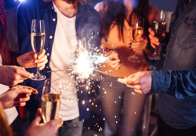 Premium Photo | Group of happy people holding sparklers at party and ...