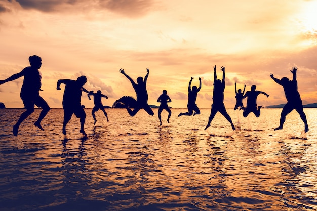 Group of man jumping on beach in sunset | Premium Photo