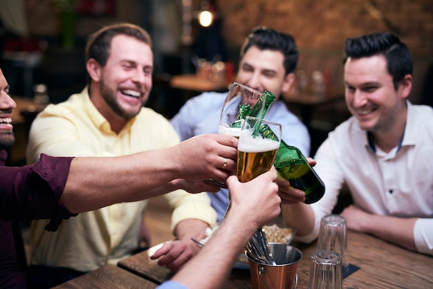 Premium Photo | Group of men making a cheers at the bar