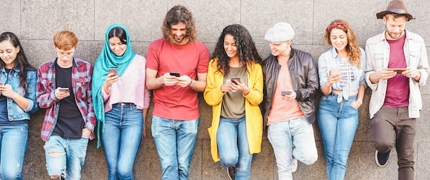 Group of millennial friends watching social story on smart mobile phones. people addiction to new technology trend Premium Photo