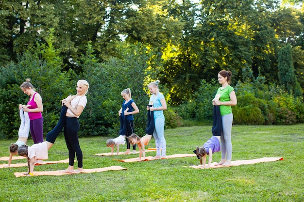 Premium Photo | Group of mothers and their children doing exercise ...