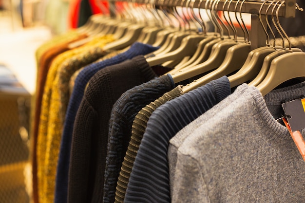 Premium Photo | Group of multi-colored sweaters hanging trempels in a ...