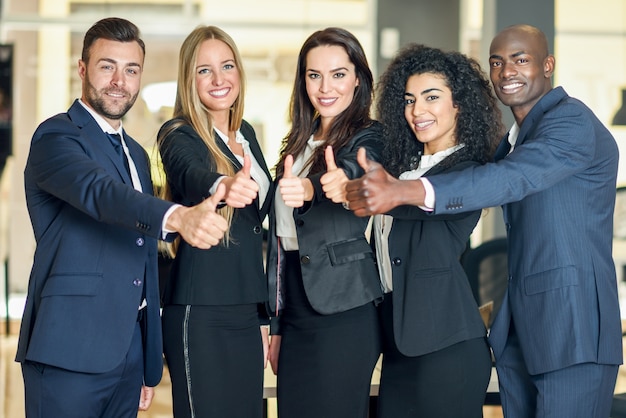 Group of businesspeople with thumbs up gesture in modern ...