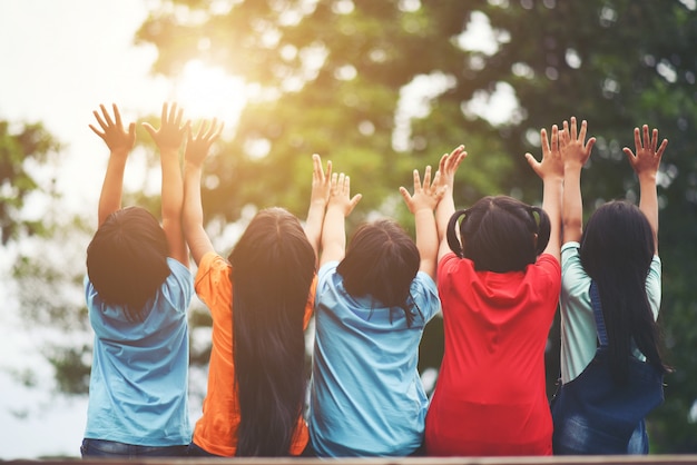 Group of kids friends arm around sitting together Free Photo