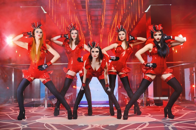 実行する赤い一致する衣装でセクシーな女性ダンサーのグループ 無料の写真