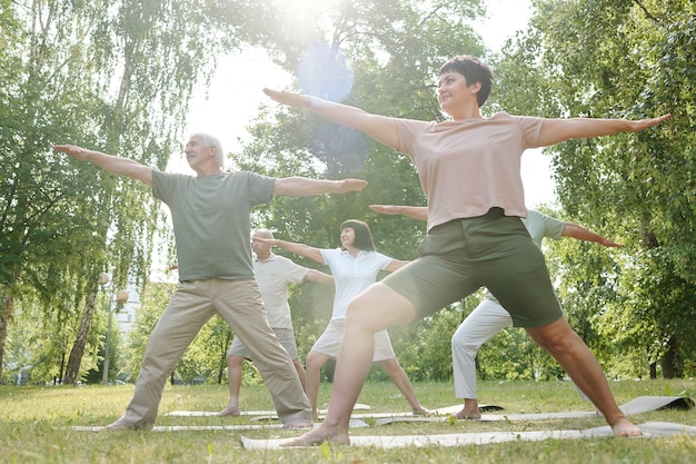 Premium Photo | Group of people standing on green grass and doing sport ...