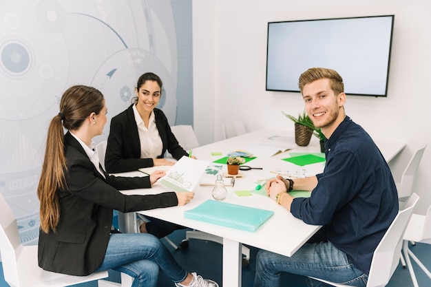 Group of smiling young businesspeople at workplace Free Photo