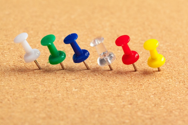 Premium Photo | Group of thumbtacks pinned on corkboard in a row close ...