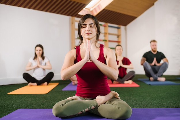 Premium Photo | A group of a young people doing joga exercises indoors ...