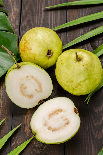 Premium Photo | Guava on the background of green palm leaves.