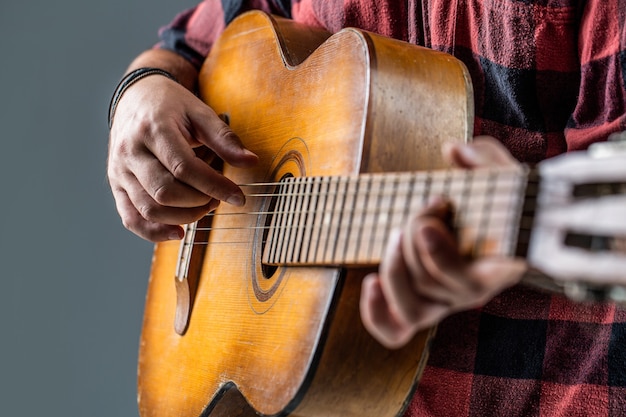 ステージ上のギタリスト ギターを弾く手をクローズアップ アコースティックギター ギター 楽器を演奏する男性ミュージシャン アコースティックギターを弾く男 の手 クローズアップ アコースティックギターの演奏 プレミアム写真