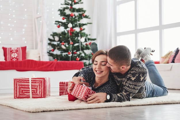 Premium Photo | Guy gives his wife christmas gift. lovely young couple ...