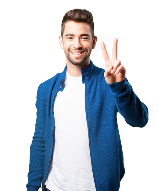 Guy in a blue jacket with victory fingers Photo | Free Download