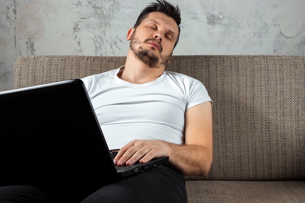 Premium Photo Guy Wearing A White Shirt Sitting On The Couch Fell Asleep At Work On A Laptop