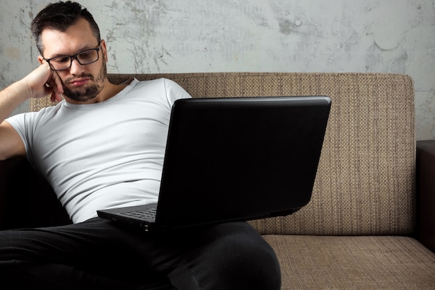 Premium Photo Guy Wearing A White Shirt Sitting On The Couch Fell Asleep At Work On A Laptop