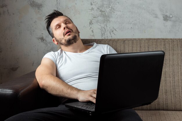 Premium Photo Guy Wearing A White Shirt Sitting On The Couch Fell Asleep At Work On A Laptop