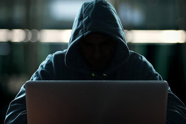 Premium Photo | Hacker in front of his computer. dark face