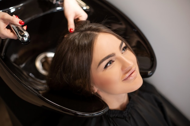Haircut master washes hair of her client's had Premium Photo