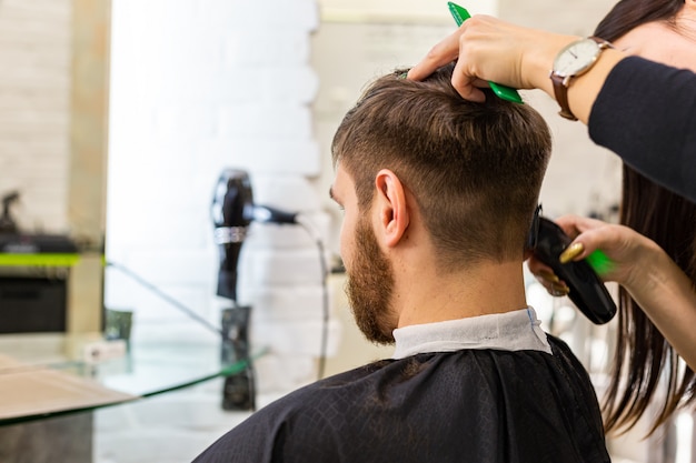 男性のクライアントの美容院の作業スペース 職場で散髪をしている美容院 美容サービス 理髪店のヘアカット プレミアム写真