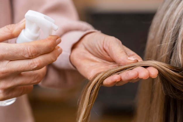 Free Photo Hairdresser Holding Tuft Of Hair And Spraying With Water