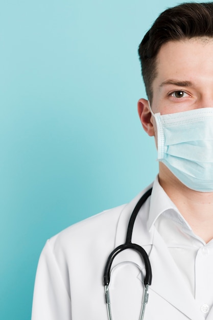 Half of doctor's face wearing medical mask and stethoscope | Free Photo