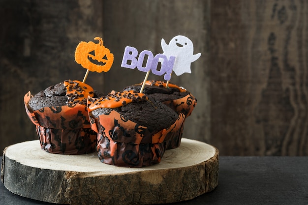 Premium Photo | Halloween chocolate muffins on wooden table. copy space