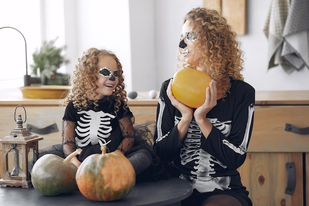 Free Photo Halloween Mother And Daughter In Mexican Style Halloween Costume Family At Home With Pumpkins