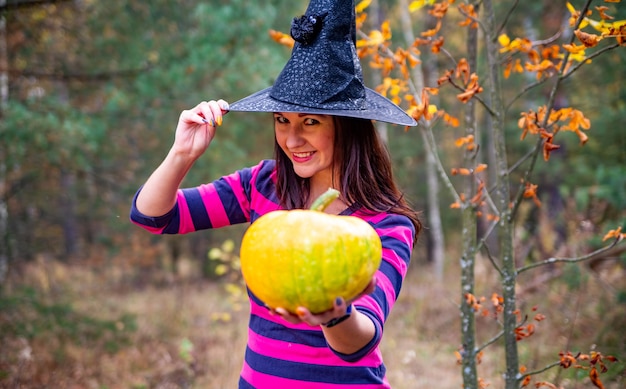 Premium Photo | Halloween warm beautiful witch with pumpkin