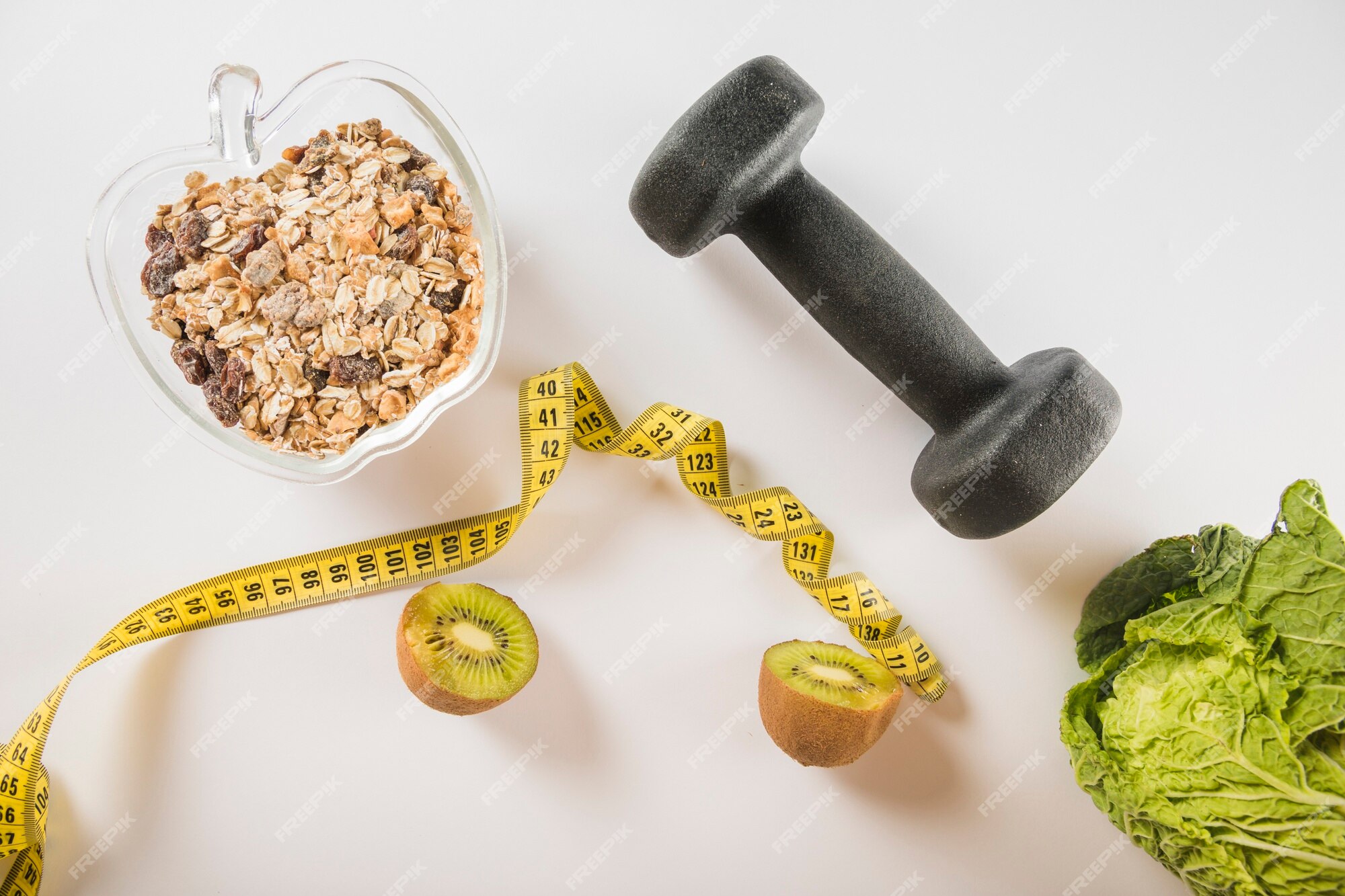 Free Photo | Halved kiwi; measuring tape; oats; dumbbell and lettuce on ...