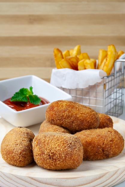 Premium Photo | Ham and chicken croquettes with tomate and chips