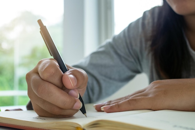 Premium Photo | The hand of a black woman holding a pen and writing ...