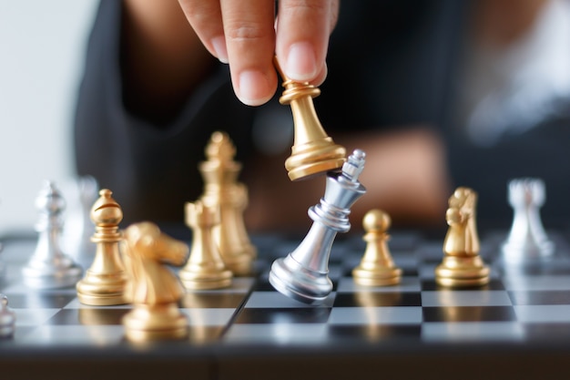 Premium Photo | Hand of business woman moving golden chess to defeat ...