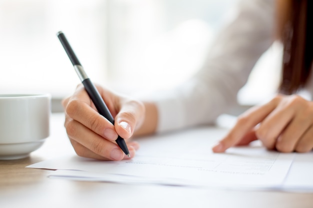 Free Photo | Hand of businesswoman writing on paper in office