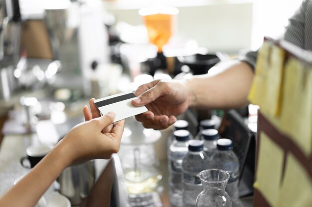 Premium Photo | Hand of the buyer gives a credit card to the seller