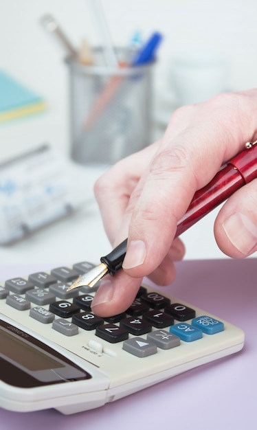 Premium Photo | Hand and a calculator